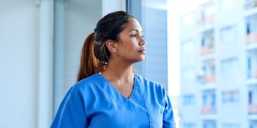 Tired nurse looking out of the window