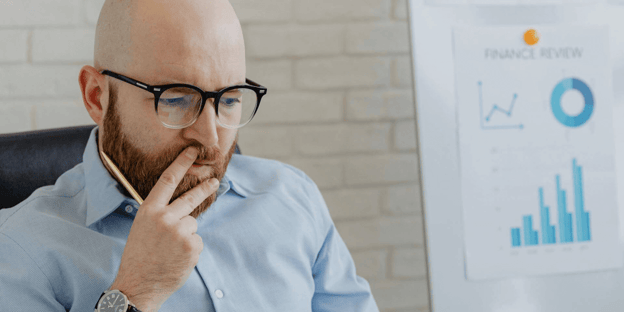 Man looking pensive with graphs in the background