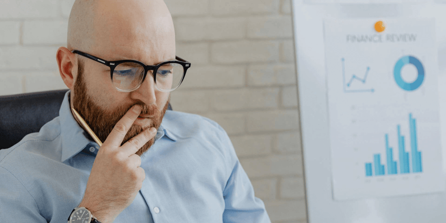 Man looking pensive with graphs in the background